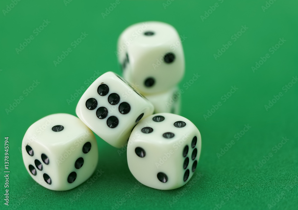 Hand dropping four white dice with black dots onto a green surfa Hand dropping four white dice with black dots onto a green surfa
