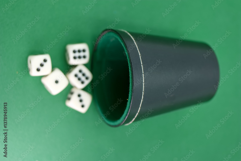 Exploring the excitement of a dice game with a cup on a green su