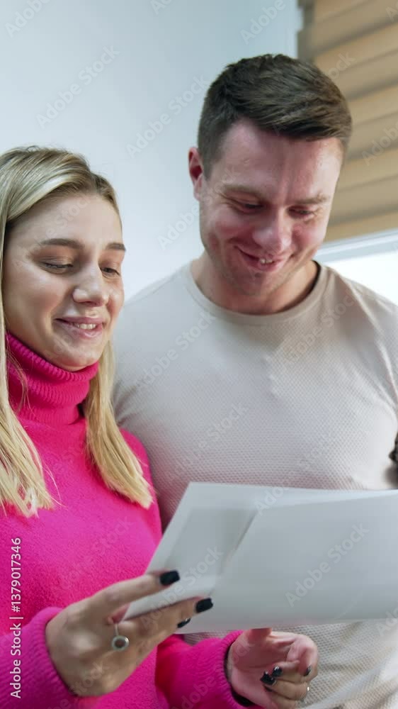 Caucasian couple looking through the images. Happy future parents see their future baby ultrasound scans. Vertical video Caucasian couple looking through the images. Happy future parents see their future baby ultrasound scans. Vertical video