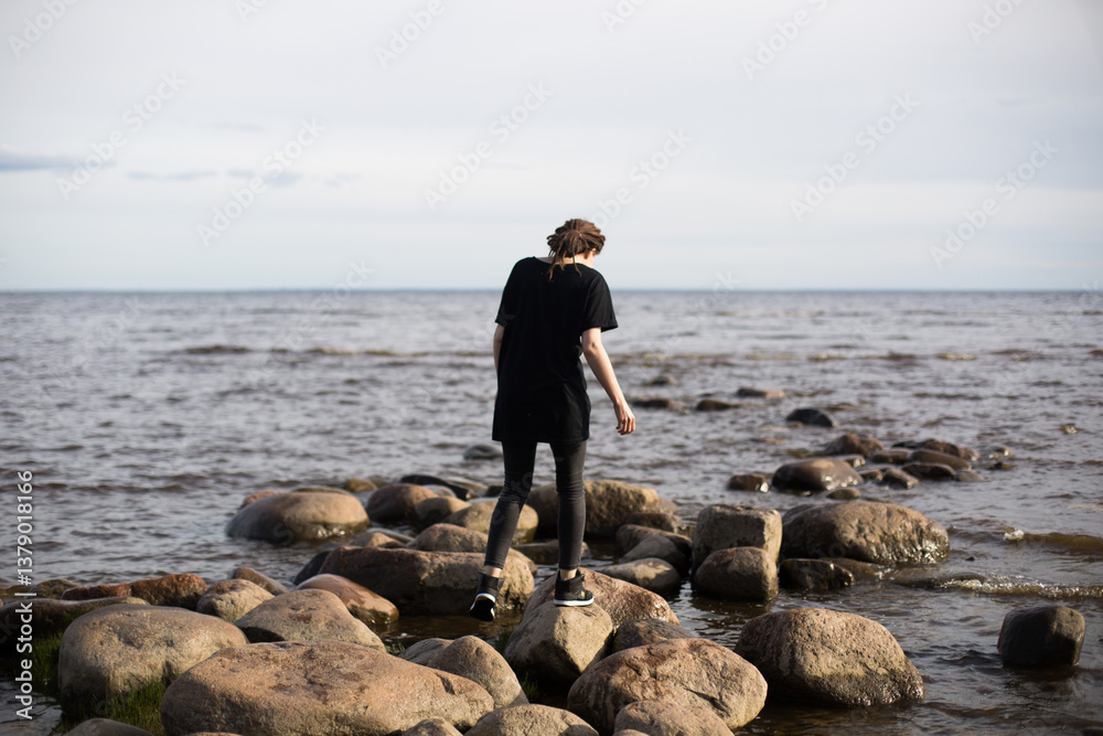 Young Woman Walking on Rocks at the Beach Young Woman Walking on Rocks at the Beach