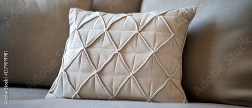 A plush, textured, white cushion sits on a sofa, showcasing its intricate geometric pattern in a cozy ambient setting.