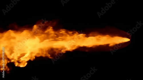 a burst of fire against a black background, captured mid-air like a flame from a flamethrower or rocket.
