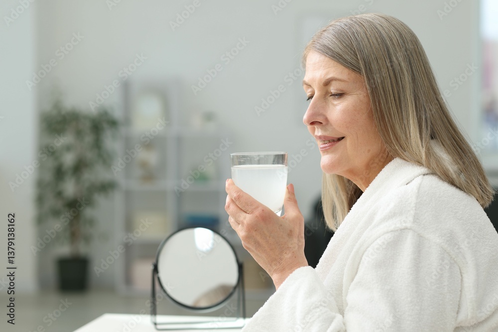 Smiling woman with glass of collagen water at home. Space for text Smiling woman with glass of collagen water at home. Space for text