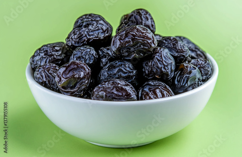 Bowl of prunes dried plums healthy snack food delicious fruit nutrition fiber diet vitamins antioxidants 100g