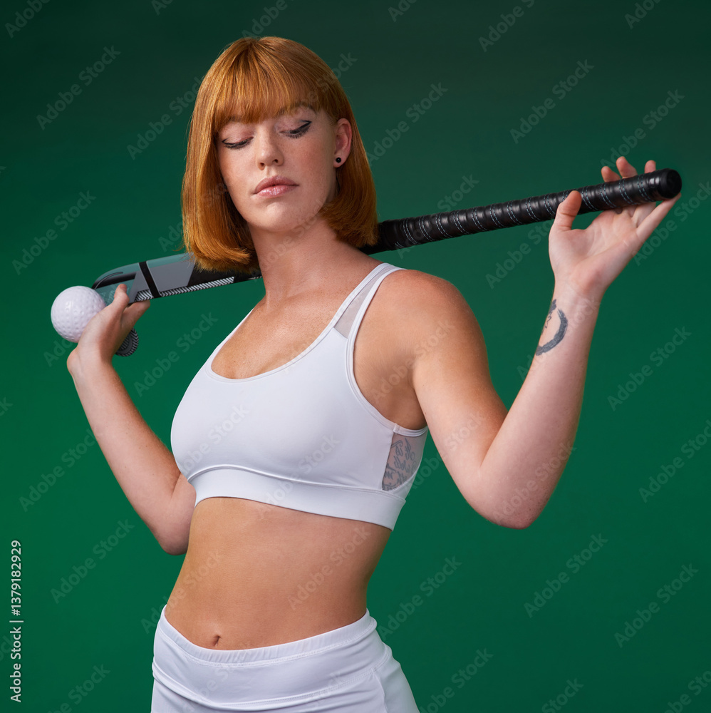 Fototapeta premium Hockey, stick and woman in studio for sport, workout challenge and training for game tournament. Female athlete, redhead and equipment in green background for practice, competition or fitness contest
