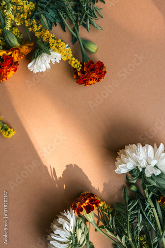 Wallpaper Mural Flat lay composition of white chrysanthemums, orange marigolds, and yellow goldenrods on a warm beige background, arranged in corners with copy space in the center Torontodigital.ca