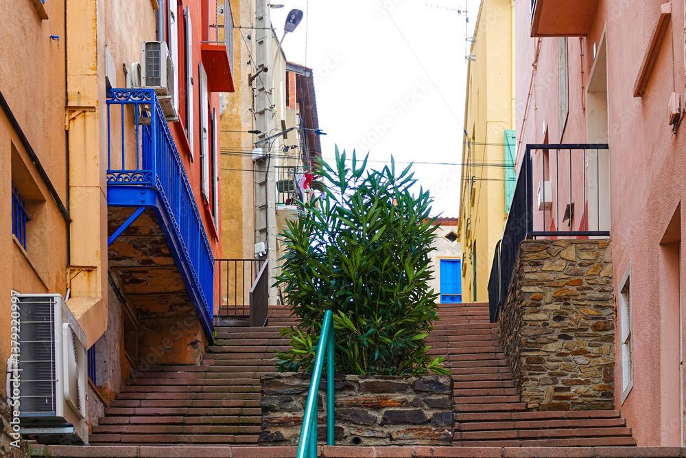 Steps lead through a picturesque alleyway, framed by colorful buildings. Port-Vendres, Occitanie, France.