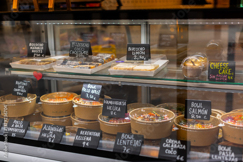 Slika na platnu Glass display filled with healthy ready-to-eat meals and desserts in a small takeaway shop