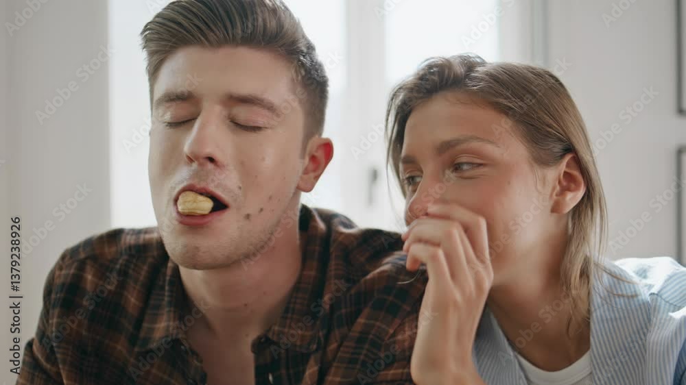 Affectionate woman feeding man with cookies closeup. Happy husband kissing wife Affectionate woman feeding man with cookies closeup. Happy husband kissing wife