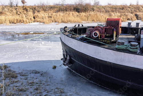 Billede på lærred The bow of a barge on an ice-bound river