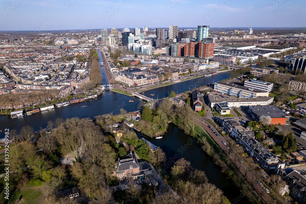 Fototapeta premium High rise buildings of financial office district and urban transportation hub seen from above with draw bridge in the froeground. Aerial airscape cityscape Utrecht, The Netherlands 