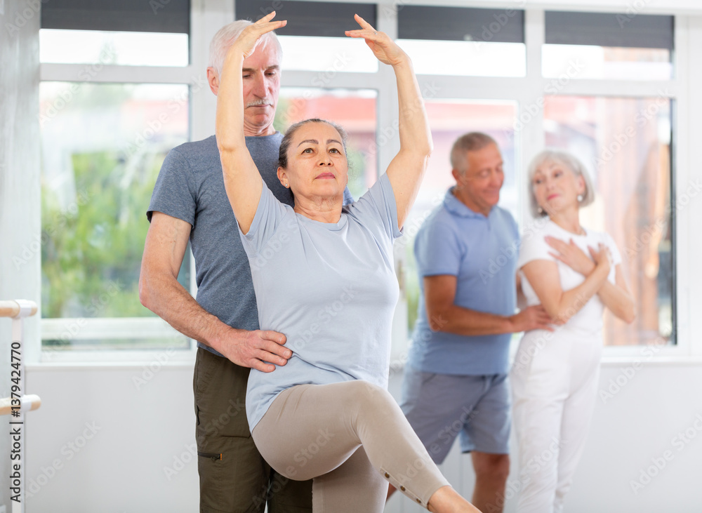 Fototapeta premium Elderly couples learning to dance ballet in a dance studio