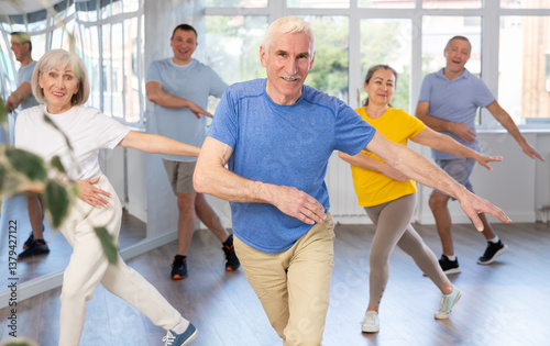 Obraz na płótnie Expressive cheerful gentleman participating in upbeat Zumba class for group of seniors in mirrored fitness studio w salonie
