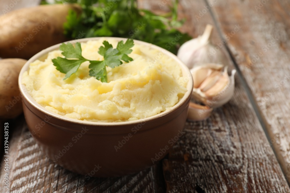 Delicious mashed potato with parsley and garlic on wooden table, closeup. Space for text Delicious mashed potato with parsley and garlic on wooden table, closeup. Space for text