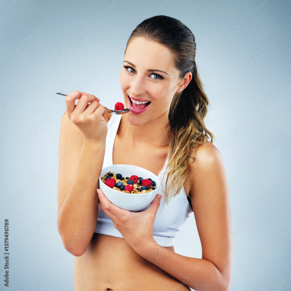 Happy woman, portrait and eating with bowl of muesli for diet or nutrition on a blue studio background. Young female person or model with smile for natural organic fruit, healthy fiber or vitamins Happy woman, portrait and eating with bowl of muesli for diet or nutrition on a blue studio background. Young female person or model with smile for natural organic fruit, healthy fiber or vitamins