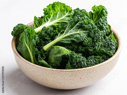 Fresh curly kale leaves in a rustic ceramic bowl on a white background .