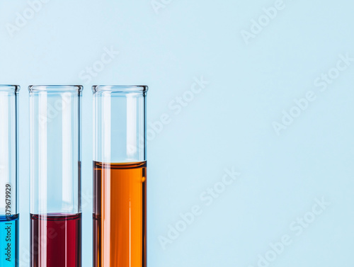 Wallpaper Mural Three test tubes filled with colorful liquids against light blue background Torontodigital.ca