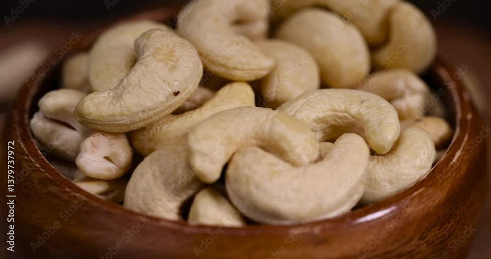 cashew nuts are scattered on a larch board, raw unroasted cashew nuts are healthy and allowed for vegans. cashew nuts are scattered on a larch board, raw unroasted cashew nuts are healthy and allowed for vegans.