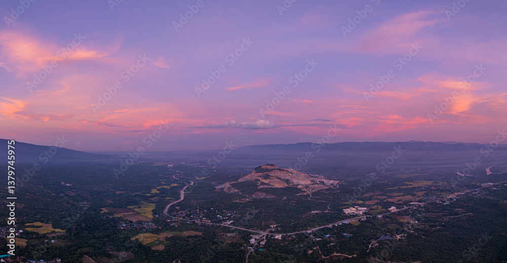 Obraz premium A breathtaking view of a colorful sunset over layered mountain silhouettes, with warm hues of orange, pink, and blue blending seamlessly across the sky.
