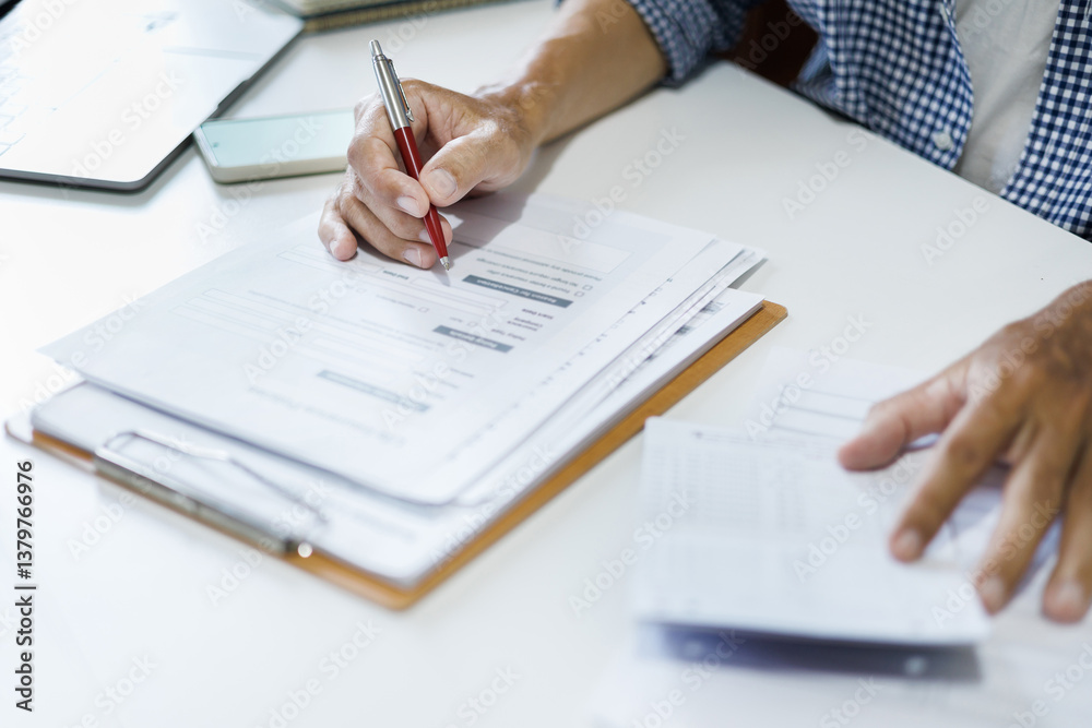 asian man reading business contract and checking passbook to apply for a loan before starting a new business asian man reading business contract and checking passbook to apply for a loan before starting a new business