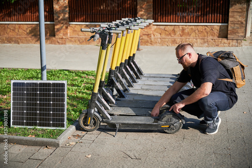 Man connects solar panel to electric scooter for charge. Integration of solar power as sustainable energy source for charging electric scooters, promoting eco-friendly urban transportation.