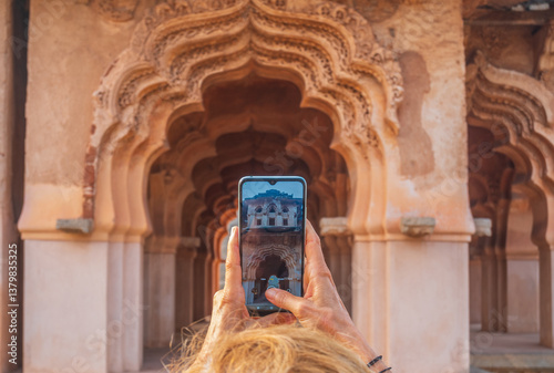 Canvas Print Woman taking photo of amazing temples at Hampi, world famous unesco site