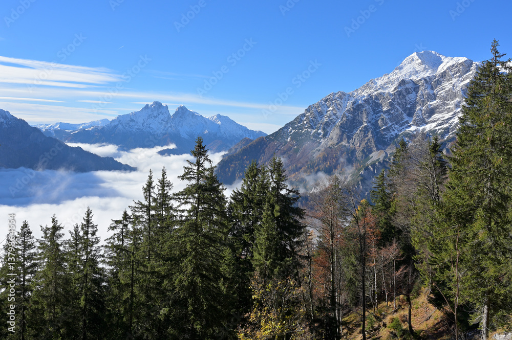Obraz premium Fall mountain landscape, blue sky, sun shines above the fog in the valley, first snow. Background the mountains Buchstein and Reichenstein. Styria, Austria.