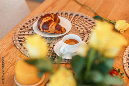 Obraz na płótnie Breakfast for two with croissants, coffee, fruit, and a yellow rose on a wooden table. A warm and elegant morning scene set for a cozy start to the day. w salonie