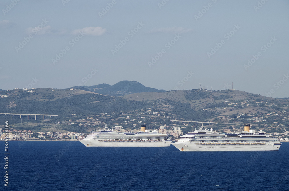 Mega family cruiseship cruise ship liners Favolosa and Fortuna anchored offshore of Civitavecchia Rome, Italy before reactived after Covid pandemic with other vessels in port and coastline