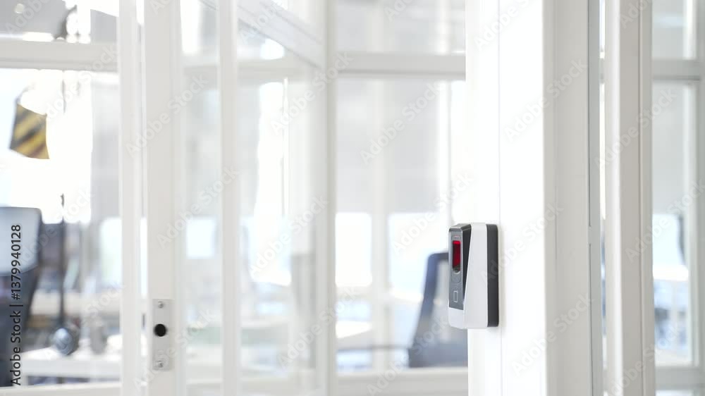 Close up of a man's hand opening a glass office door holding a doorknob in a modern business center. A man, businessman or employee in a shirt opens the door and enters office to workplace. Rear view