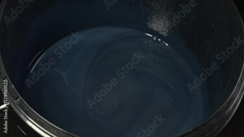 Combining Blue Paint in a Large Bucket for Various Creative Projects