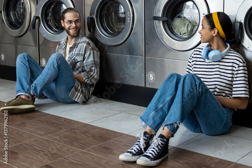 Man and woman communicating and completing their routine washing chore in public laundromat service