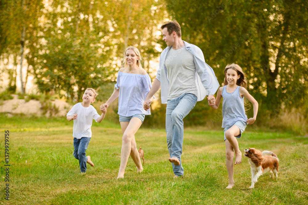 Obraz premium Mom, dad, boy, girl enjoy country rest holding hands, running barefoot on grass, laughing happily. Family running together with dog. Summer family weekend concept, country rest, activity together