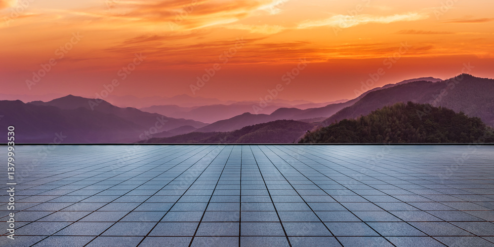 Empty square floor and beautiful mountain range during vibrant orange sunset