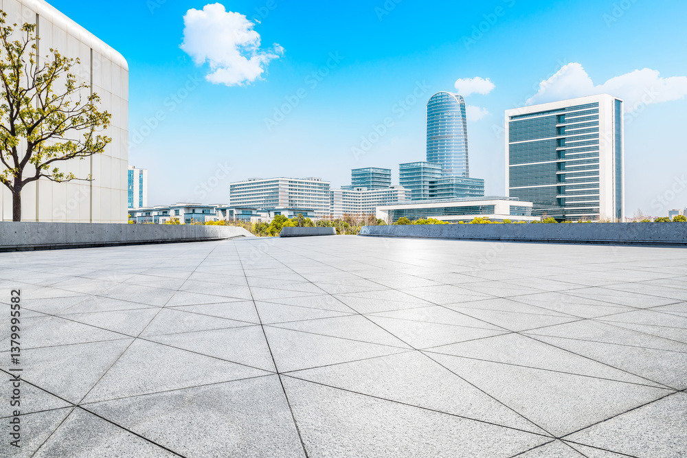 Empty square floor with modern cityscape and office buildings under blue sky