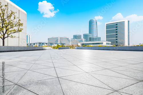Obraz na płótnie Empty square floor with modern cityscape and office buildings under blue sky w salonie