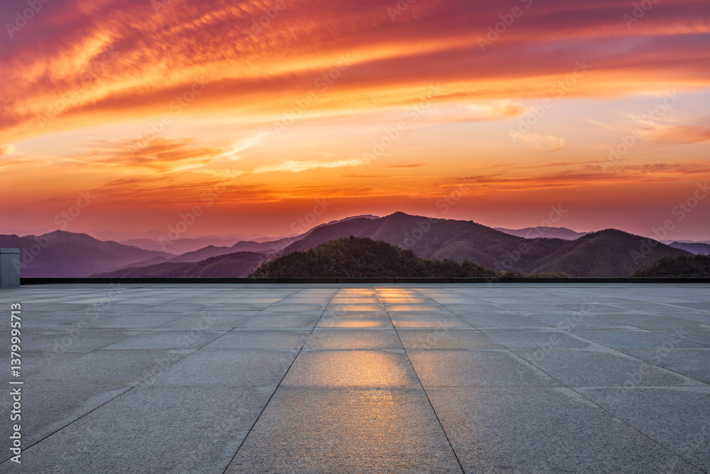 Empty square floor and beautiful mountain range during vibrant orange sunset