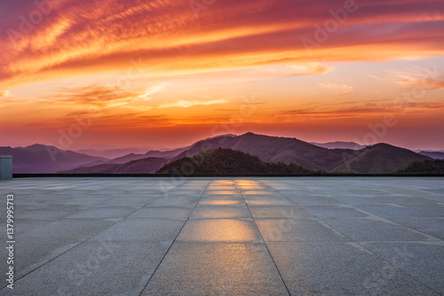 Obraz na płótnie Empty square floor and beautiful mountain range during vibrant orange sunset w salonie