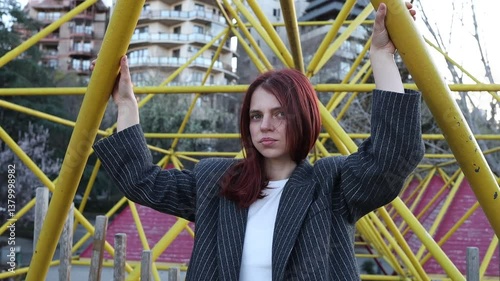 Beautiful girl with red hair posing on yellow background. Woman in jacket posing. Woman in business suit smiling. Red-haired girl with beautiful smile posing.