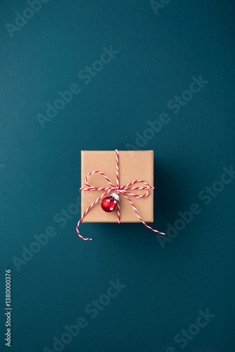 Gift box wrapped in kraft paper tied with candy cane Christmas rope on dark b...