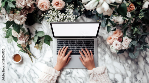 Obraz na płótnie A woman is typing on laptop with white empty screen surrounded by beautiful flowers w salonie