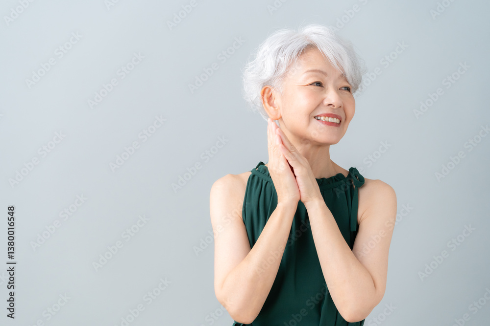 グレーバックでスキンケアをするシニアの女性 グレーバックでスキンケアをするシニアの女性