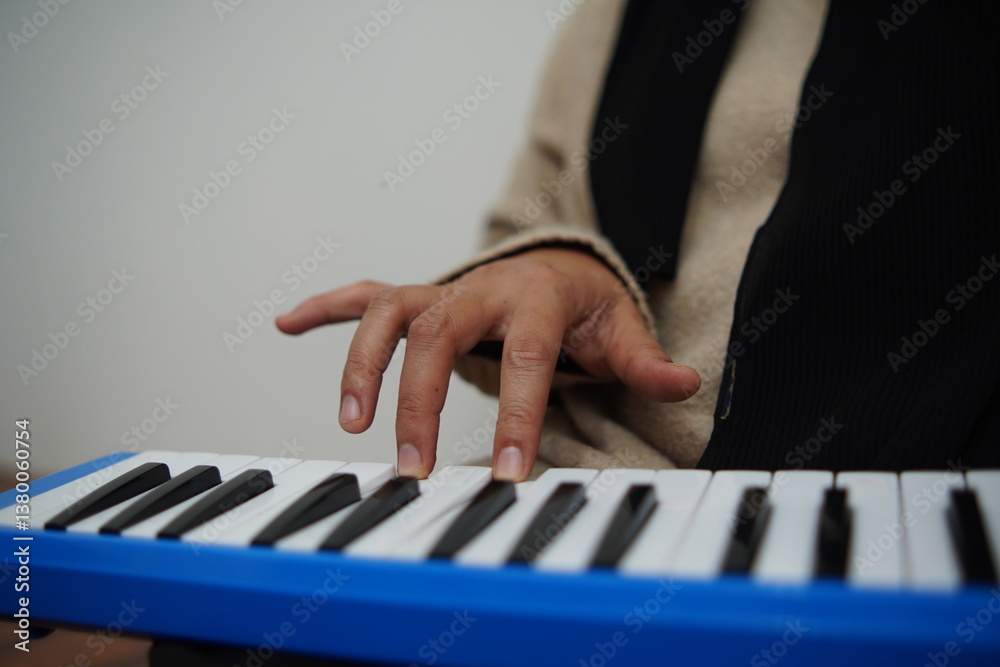 Obraz premium Anonymous woman playing pianica, melodica blow organ