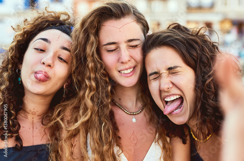 Outdoor, silly and faces of friends for travel, vacation and summer holiday with hug in Spain. People, happy women and funny with tongue out for adventure, connection and bonding with emoji reaction
