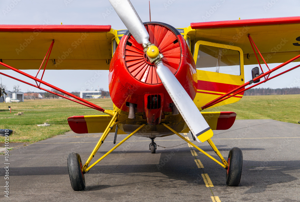 old multi-role aircraft after renovation. red and yellow aircraft of Soviet design. front view of the aircraft standing on the airport apron. old multi-role aircraft after renovation. red and yellow aircraft of Soviet design. front view of the aircraft standing on the airport apron.