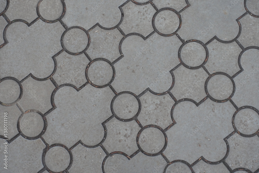 Close view of pavement of curved gray interlocking concrete tiles