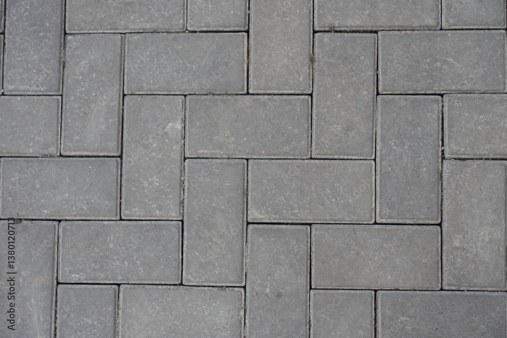 Closeup of grey concrete pavement with single herringbone layout