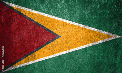Guyana state flag on a metal surface. Dirty grunge Guyana flag.