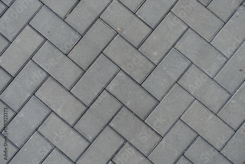 Top view of grey concrete pavement with single herringbone layout