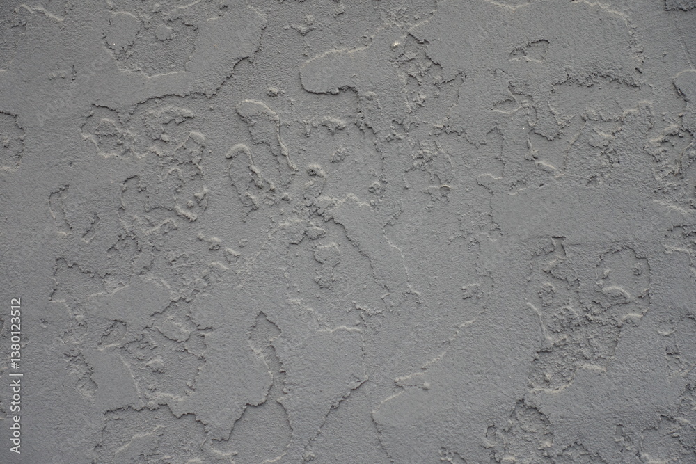 Close view of gray wall with troweled dash stucco finish